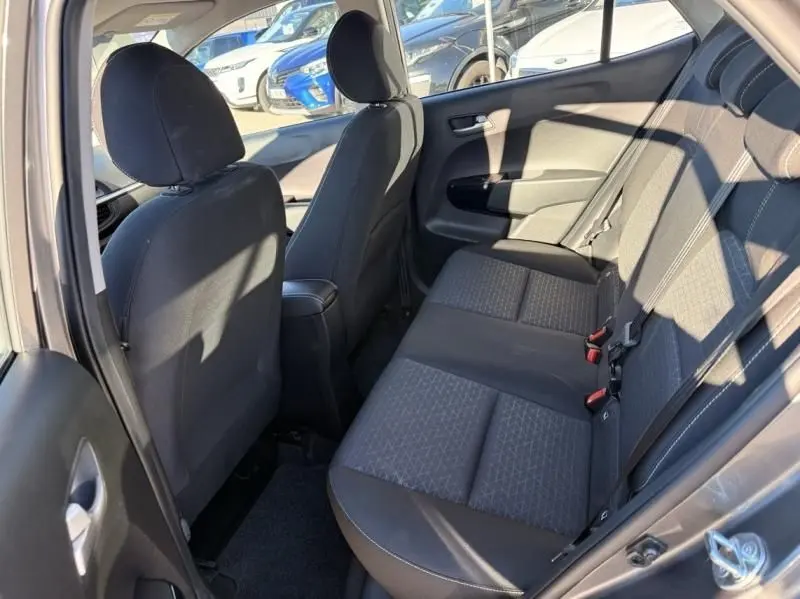 Vue intérieure arrière côté gauche du Kia Picanto 2023 gris foncé, montrant les sièges arrière en tissu noir avec motifs.