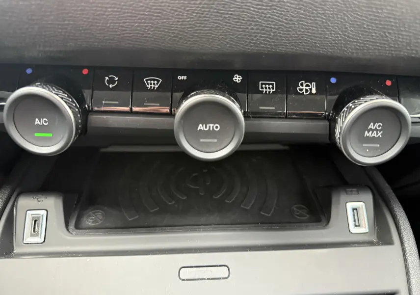 Vue rapprochée du tableau de commande de climatisation avec trois boutons rotatifs et deux ports USB dans une Citroën C4 Hybrid 2025.