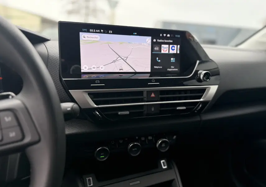 Vue intérieure centrée sur l’écran tactile du tableau de bord du Citroën C4 Hybrid 145, avec commandes de climatisation visibles.