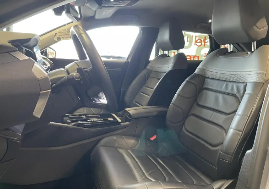 Intérieur de la Citroën C5 X 2024 en cuir noir, vue côté conducteur avec tableau de bord et console centrale visibles.