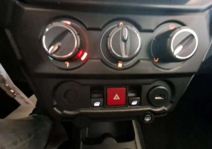 Vue rapprochée des commandes de climatisation et des boutons centraux dans l'habitacle de l'AIXAM AMBITION gris clair 2024.