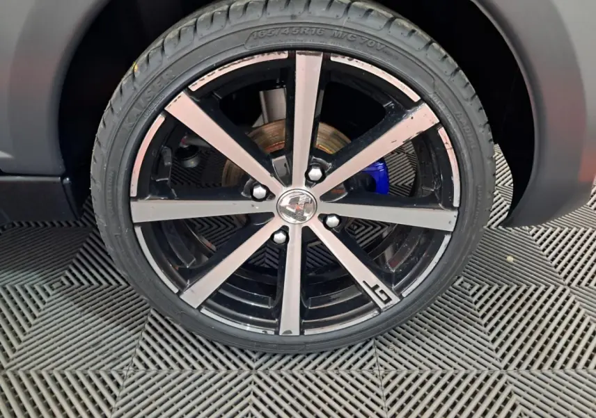 Gros plan sur la jante alliage 16’’ noires diamantées avec logo GT de l’AIXAM AMBITION gris clair 2024.