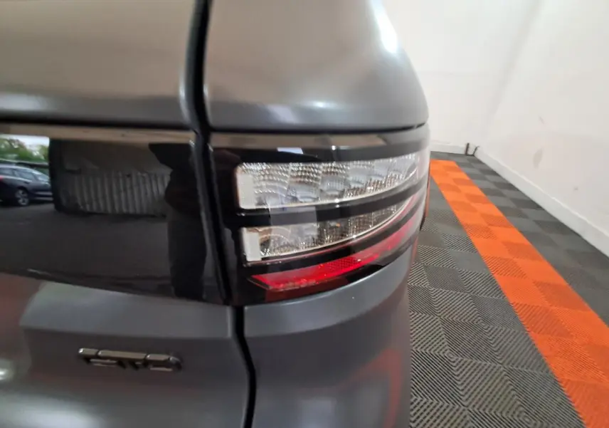 Gros plan sur le feu arrière droit gris clair de l'AIXAM AMBITION 0.5 CITY GTO avec logo GTO visible.