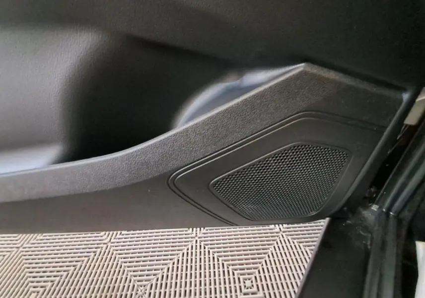 Gros plan sur le panneau de porte intérieur noir de l’Aixam Ambition 2024, mettant en valeur l’enceinte intégrée.