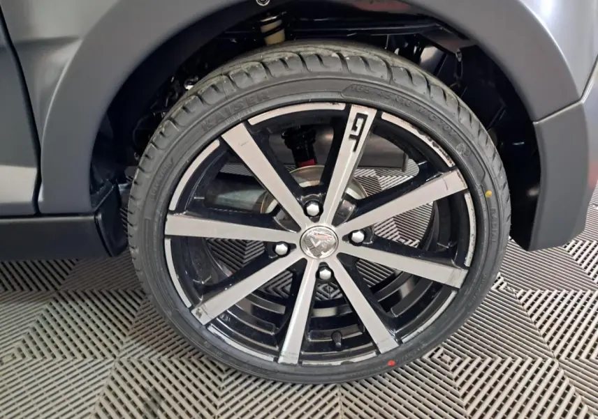 Gros plan sur la jante alliage 16’’ noires diamantées côté gauche de l’Aixam Ambition gris clair 2024.