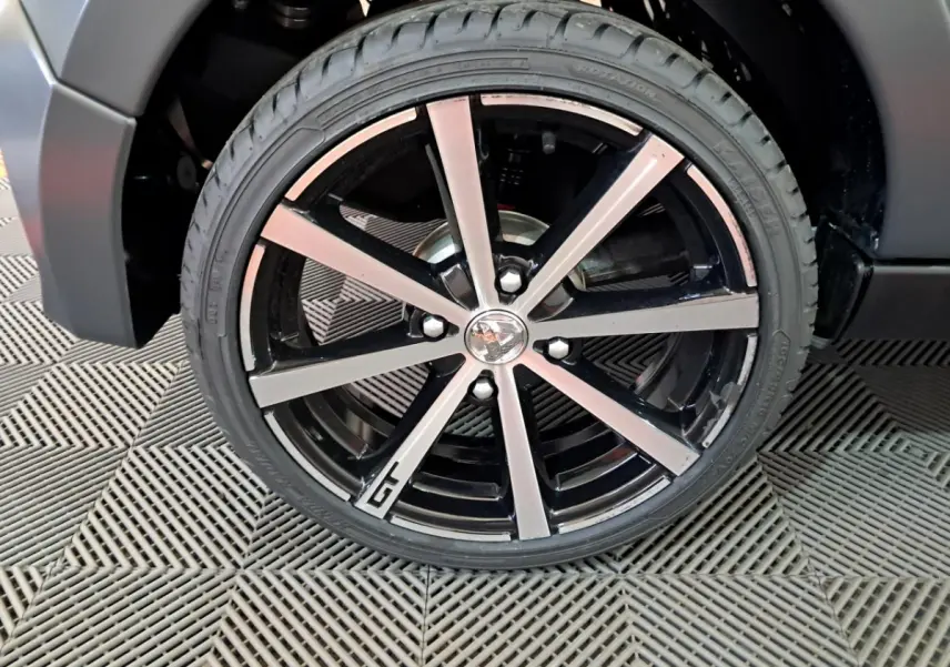 Gros plan sur la jante alliage 16’’ noires diamantées avec logo GT de l’Aixam Ambition gris clair 2024.