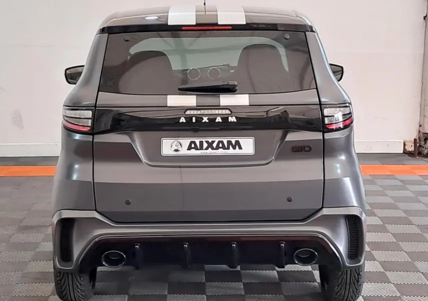 Vue arrière d'une Aixam Ambition gris clair 2024 avec bandes blanches et double sortie d'échappement intégrée.