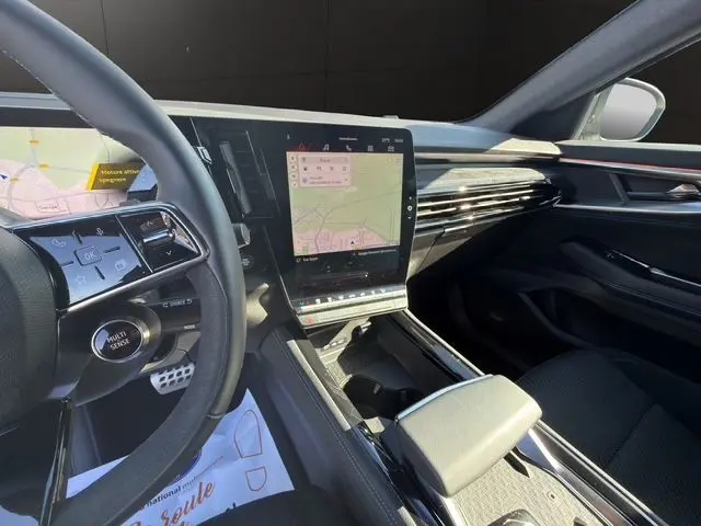 Intérieur du Renault Austral 2025, vue côté conducteur, tableau de bord moderne avec écran tactile vertical et finitions noires élégantes.