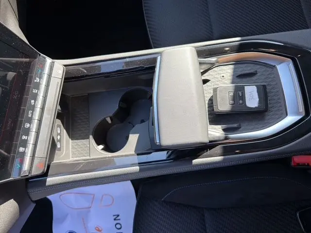 Vue plongeante sur la console centrale du Renault Austral 2025, avec porte-clés et accoudoir en cuir gris.