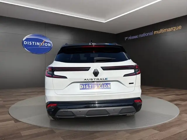 Vue arrière d'un Renault Austral blanc nacré avec toit noir, hayon motorisé et feux arrière LED en ligne continue.