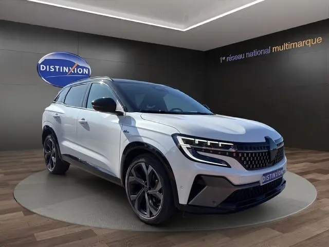 Vue 3/4 avant d’un Renault Austral blanc nacré avec toit noir, hayon motorisé et jantes alliage noires.