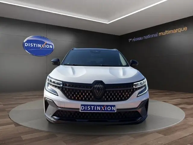 Vue frontale du Renault Austral 2025 blanc nacré avec toit noir, mettant en valeur sa calandre distinctive et son logo Renault.