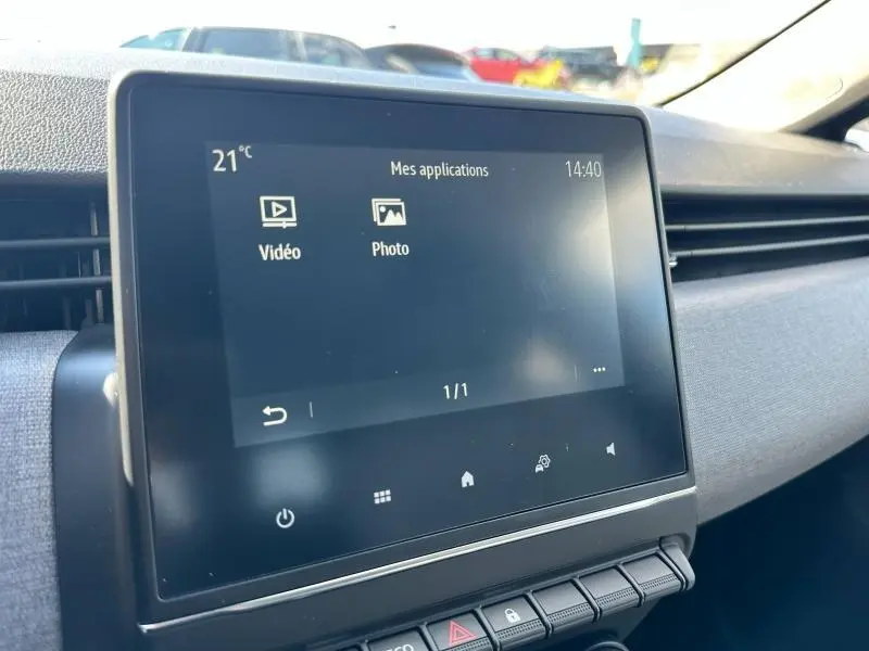 Écran tactile central de la Renault Clio 2025 affichant les applications vidéo et photo, avec tableau de bord gris clair.