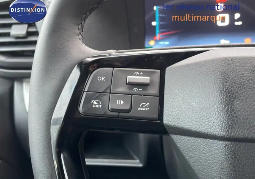 Gros plan sur les commandes de régulateur de vitesse au volant en cuir noir du Citroën Jumpy Long gris titane.