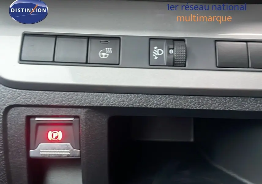 Gros plan sur les commandes du tableau de bord du Citroën Jumpy Long gris titane, avec bouton frein à main électronique allumé.
