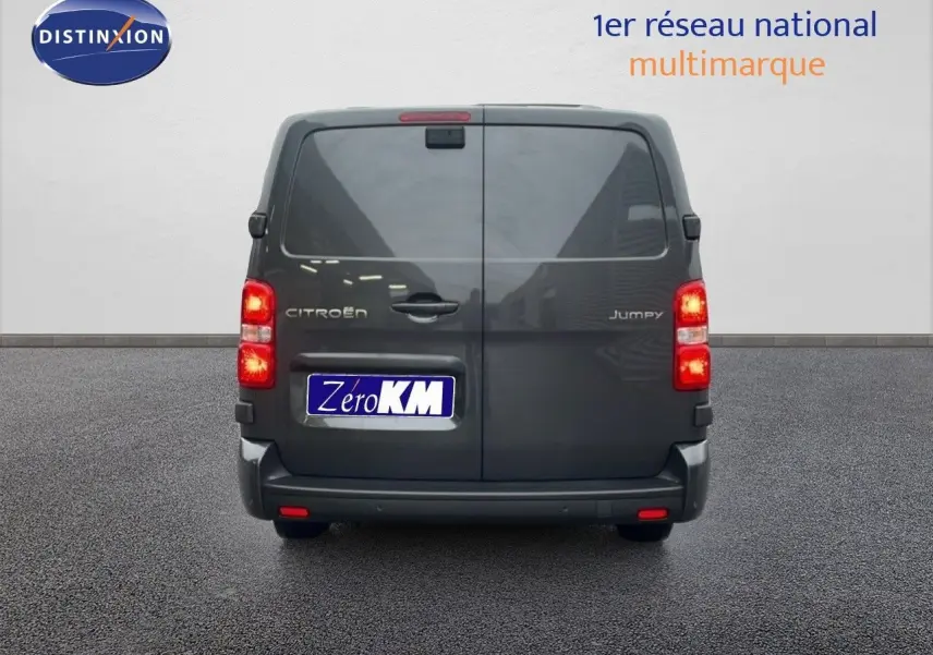 Vue arrière d’un Citroën Jumpy Cabine Approfondie gris titane métal avec feux allumés sur fond neutre.