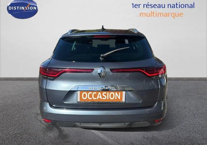 Vue arrière d’une Renault Mégane Break gris titanium métallisé avec feux LED et plaque d’immatriculation orange "OCCASION".