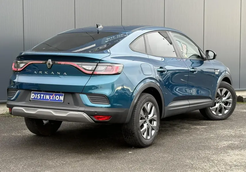 Vue 3/4 arrière droite d’un Renault Arkana bleu Zanzibar avec feux arrière LED et vitres surteintées.