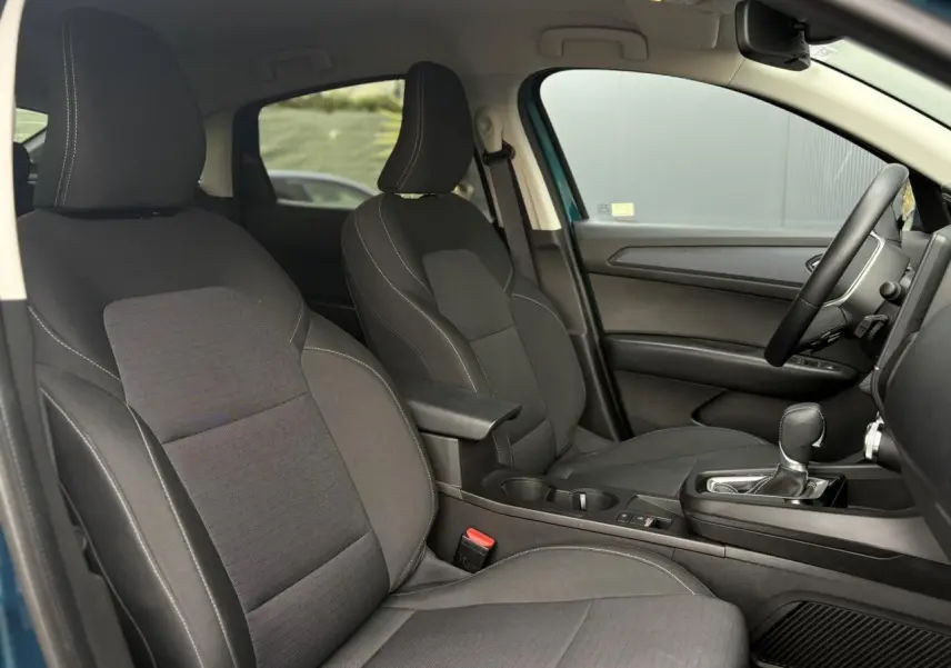 Vue intérieure côté droit du Renault Arkana 2025, sièges tissu noir avec accoudoir central et levier de boîte automatique.