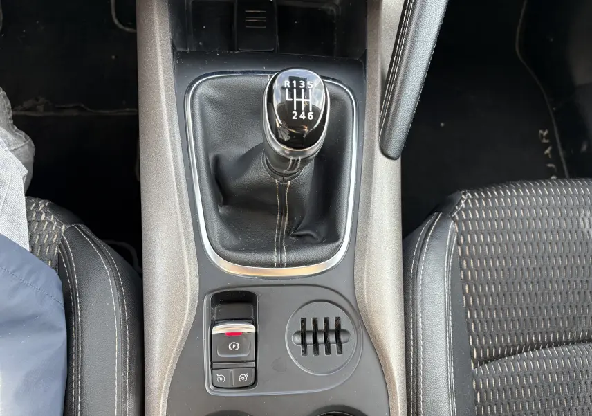 Vue plongeante sur la console centrale du Renault Kadjar 2015, boîte manuelle noire avec levier de vitesses et sièges tissu.
