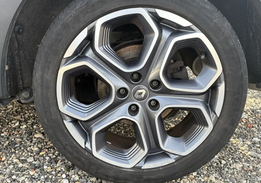 Gros plan sur la roue avant gauche d'un Renault Kadjar blanc 2015, avec jante alliage et pneu Continental.