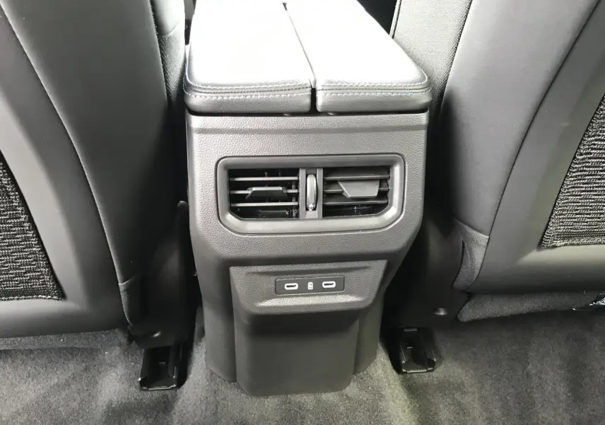 Vue rapprochée de la console centrale arrière noire avec bouches d’aération et ports USB du Renault Austral 2025.