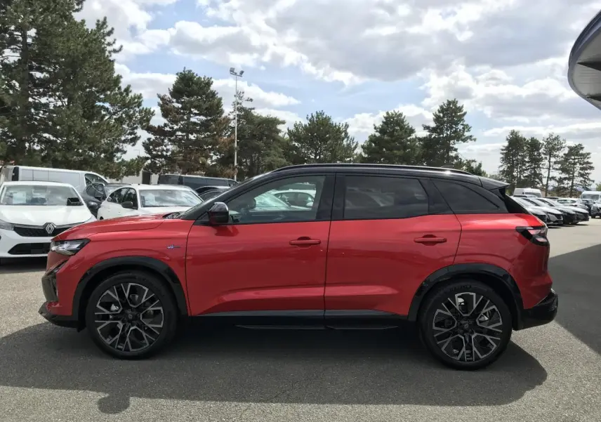 Profil droit du Renault Austral 2025 bi-ton rouge et noir avec jantes alliage noires et toit noir.