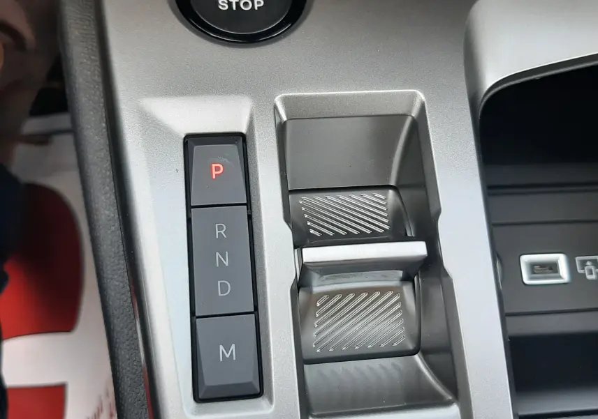 Gros plan sur la console centrale grise avec boutons de boîte auto et bouton start/stop de la Peugeot 308 2026.