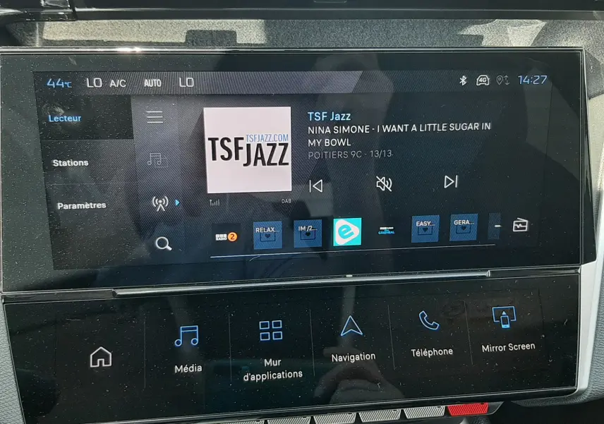 Écran tactile central de la Peugeot 308 gris Selenium, affichant la radio TSF Jazz avec commandes multimédia visibles.