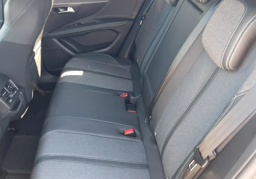 Vue intérieure côté droit montrant la banquette arrière en tissu gris et cuir noir du Peugeot 3008 2023.