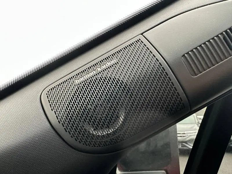 Gros plan sur l'enceinte Harman Kardon intégrée dans l'angle supérieur gauche de l'habitacle du Renault Captur 2025.