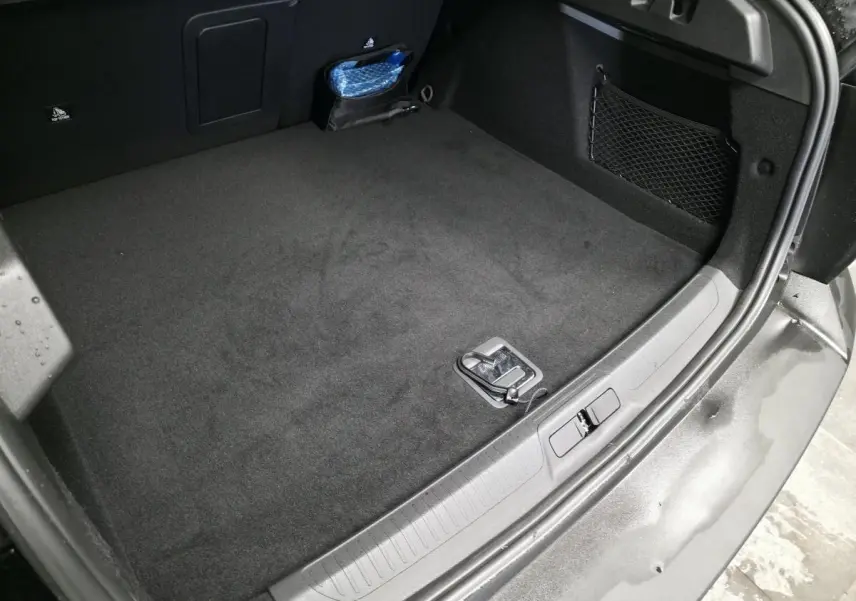 Coffre ouvert du Peugeot 408 noir Perla Nera, vue plongeante montrant un espace de chargement propre avec filet latéral.