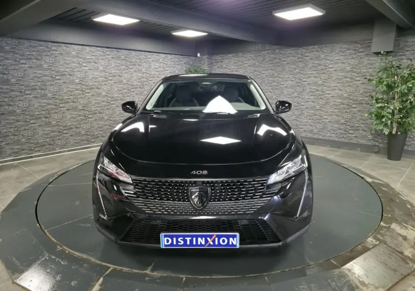 Vue avant d'une Peugeot 408 électrique noire Perla Nera, avec calandre distinctive et phares LED dans un showroom.