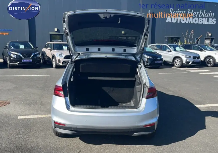 Vue arrière d'une Skoda Fabia Reflex Silver avec coffre ouvert sur un parking extérieur ensoleillé.