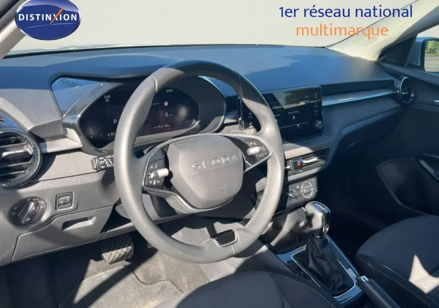 Intérieur de la Skoda Fabia 2025 en vue avant, volant multifonction, tableau de bord numérique et console centrale avec boîte auto.