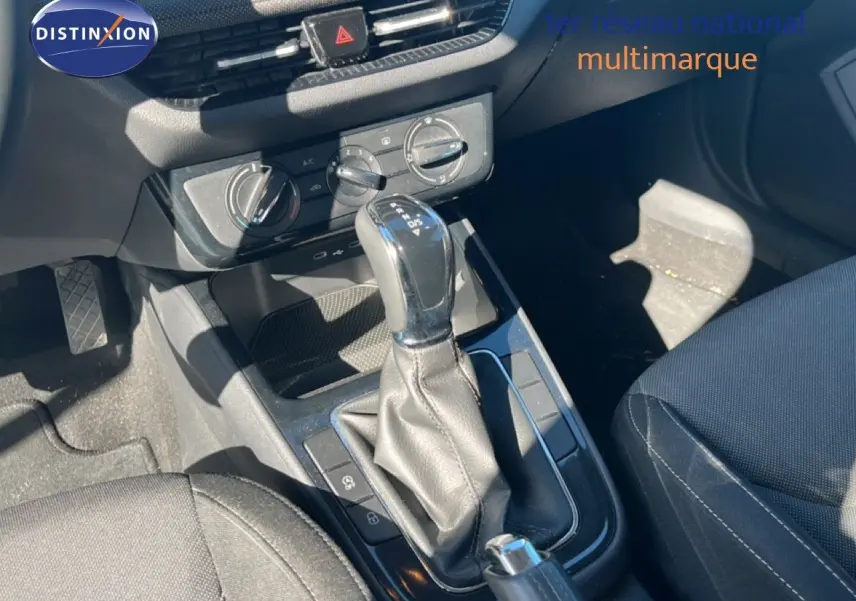 Gros plan sur la console centrale de la Skoda Fabia 2025 en Reflex Silver, mettant en valeur le levier de vitesse automatique et les commandes de climatisation.