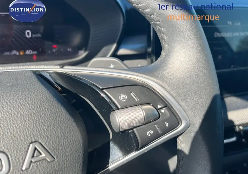 Gros plan sur les commandes multifonctions à droite du volant en cuir noir de la Skoda Fabia 2025.