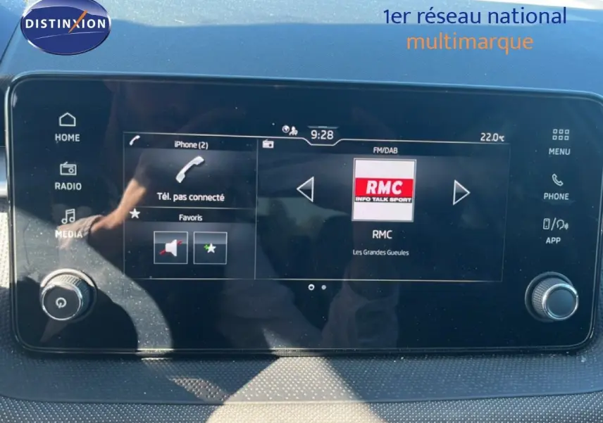 Écran tactile central du Skoda Fabia 2025 affichant la radio RMC, avec commandes multimédia et climatisation visibles.