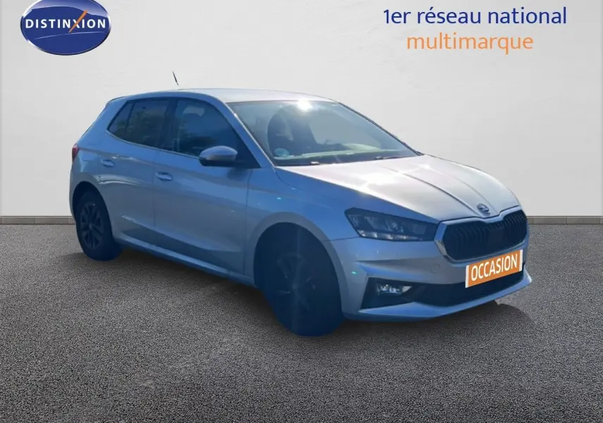 SKODA Fabia 2025 gris argenté en 3/4 avant, avec calandre noire et jantes foncées, sur fond neutre.