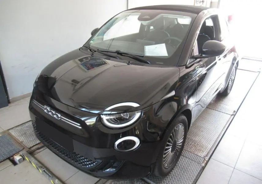 Vue 3/4 avant droite d'une Fiat 500 Cabriolet électrique noire avec jantes alliage 16'' et capote fermée.