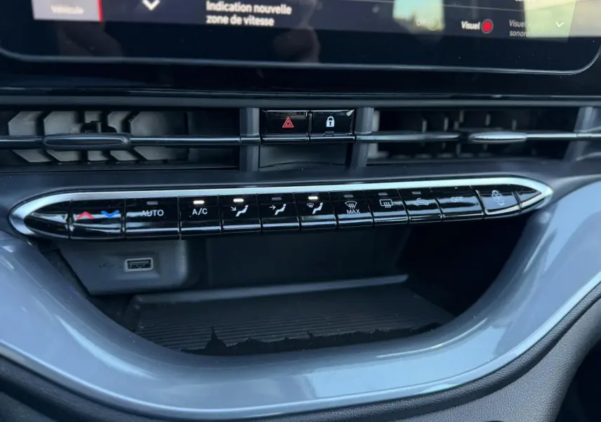 Vue rapprochée des commandes de climatisation et ventilation sur la console centrale de la Fiat 500 Cabriolet électrique noire 2024.