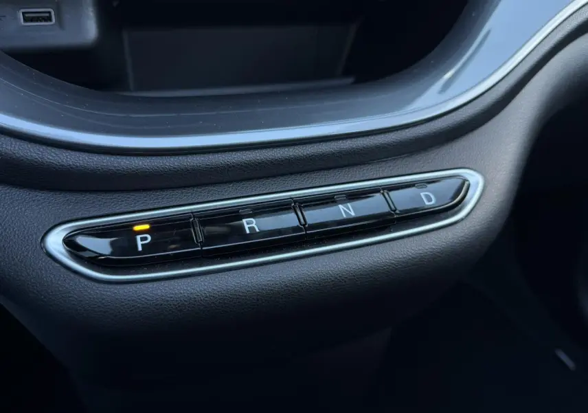Gros plan sur la commande de boîte automatique noire avec bouton P allumé dans une Fiat 500 Cabriolet électrique 2024.