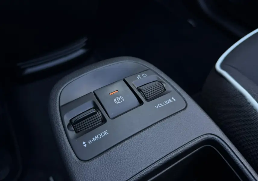 Gros plan sur la console centrale noire de la Fiat 500 Cabriolet électrique, avec commandes e-Mode et volume.