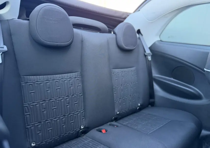 Vue rapprochée de la banquette arrière noire avec motifs FIAT embossés du cabriolet électrique FIAT 500 Icone 2024.
