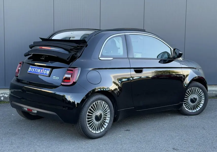 Vue 3/4 arrière droite d'une Fiat 500 Cabriolet électrique noire avec capote repliée et jantes alliage 16 pouces.