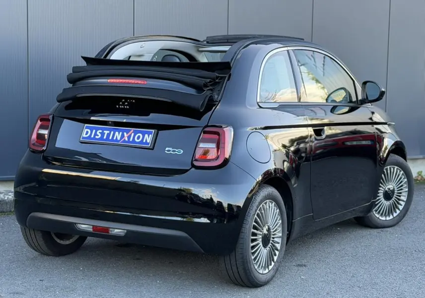 Vue 3/4 arrière droite d'une FIAT 500 cabriolet électrique noire avec capote repliée et jantes alliage 16 pouces.
