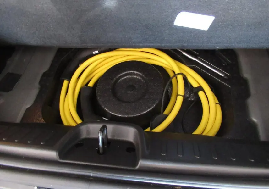 Coffre ouvert du Fiat 500 Cabriolet électrique noir 2024, montrant le câble de recharge jaune enroulé.