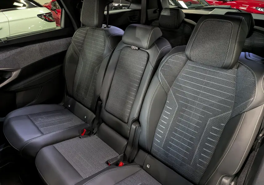 Vue intérieure sur les sièges arrière en cuir noir et tissu gris du Peugeot 5008 Hybrid 145 CH e-DCS6 GT 2025.