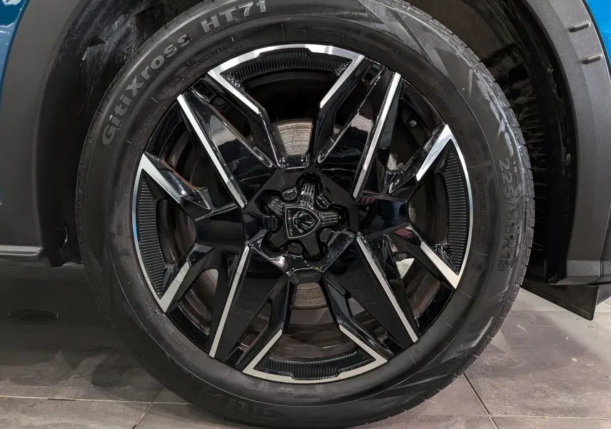 Gros plan sur la jante noire et argentée de 19 pouces du Peugeot 5008 Hybrid 145 CH e-DCS6 GT Bleu Obsession.