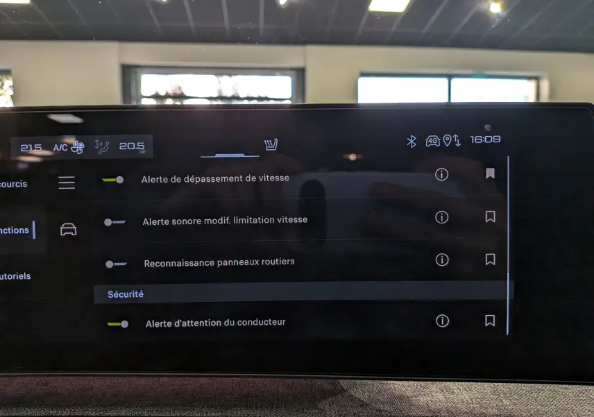 Écran tactile intérieur du Peugeot 5008 Hybrid 2025 affichant les réglages d’alerte de sécurité et climatisation.